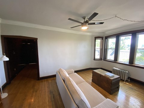 a living room with a couch and a ceiling fan