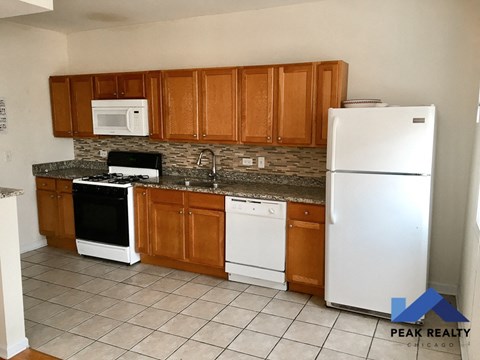 a kitchen with white appliances and wooden cabinets