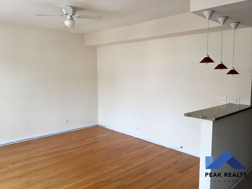 an empty living room with wood flooring and white walls