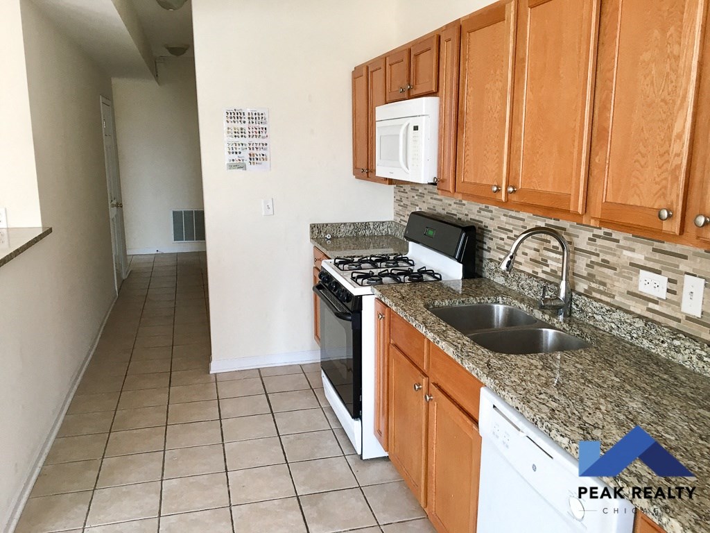 a kitchen with wood cabinets and granite counter tops and a sink and stove