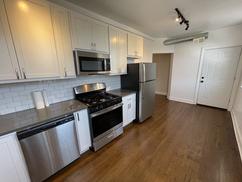 A kitchen with a stove top oven and a refrigerator.