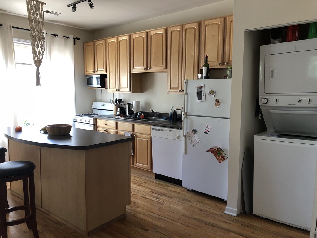 a kitchen with white appliances and wooden cabinets