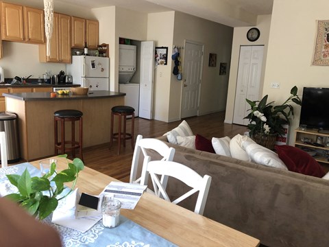 a view of the living room and kitchen from the dining room table