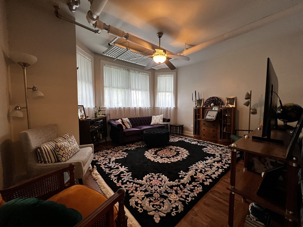 a living room with a large rug in the center of it