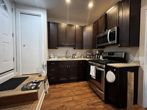 a kitchen with dark wood cabinets and stainless steel appliances