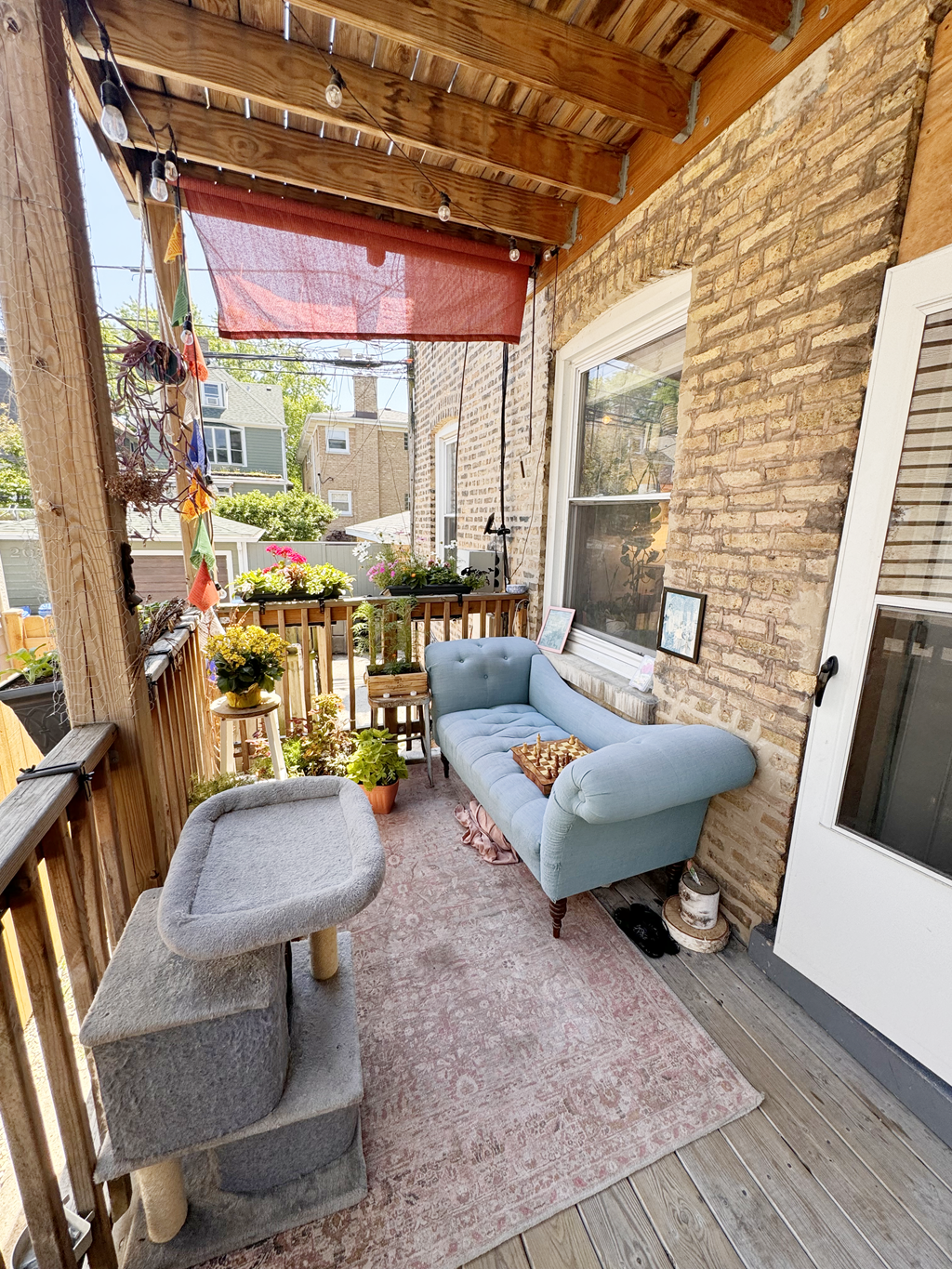 a patio with a blue couch and a chair on a porch