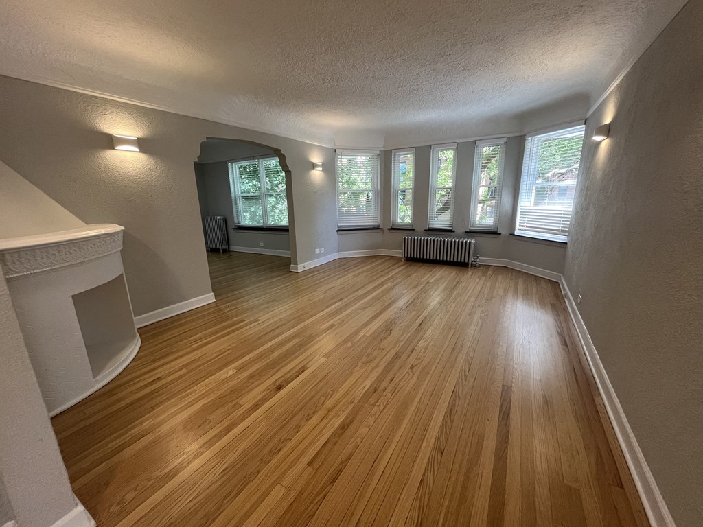 an empty living room with wood floors and windows