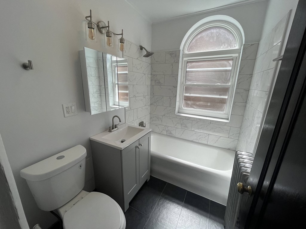 a bathroom with a toilet and a sink and a bath tub