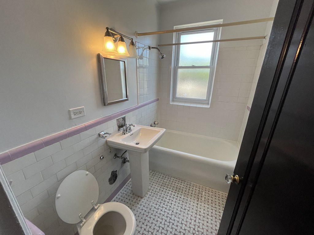 a bathroom with a toilet and a sink and a bath tub
