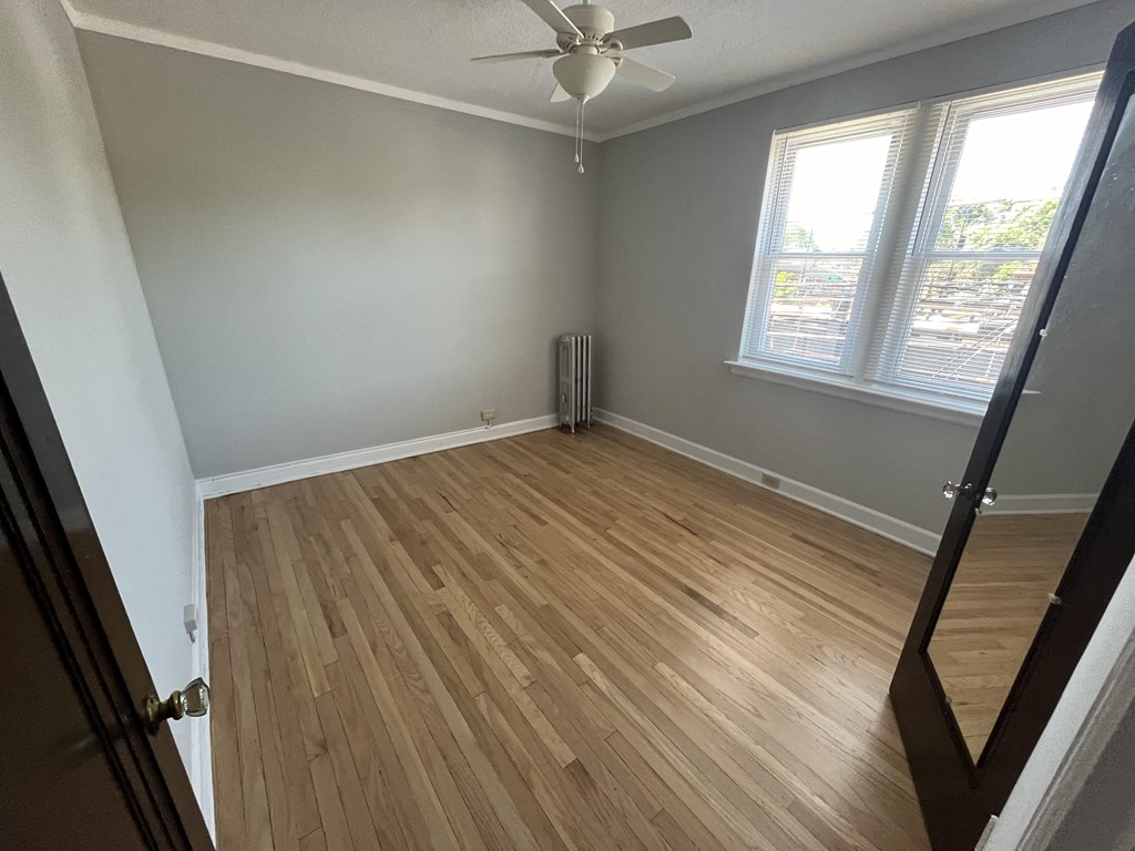 a living room with wood floors and a ceiling fan