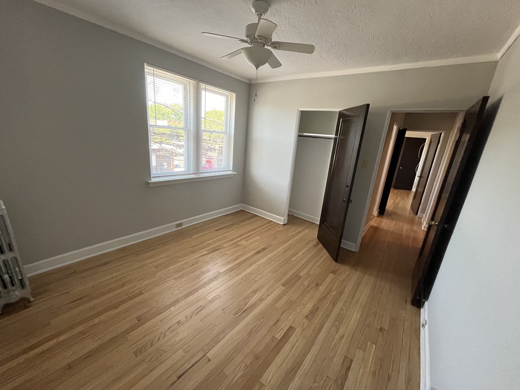 a living room with wood floors and a ceiling fan
