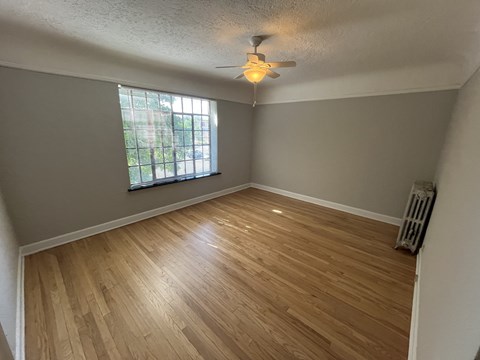 A room with wooden flooring and a ceiling fan.