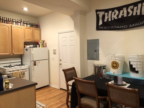 A kitchen with a Thrash Skateboard Magazine on the wall.