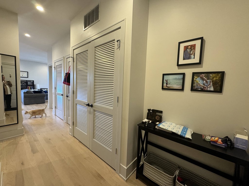 a hallway with white doors and a dog walking in the distance