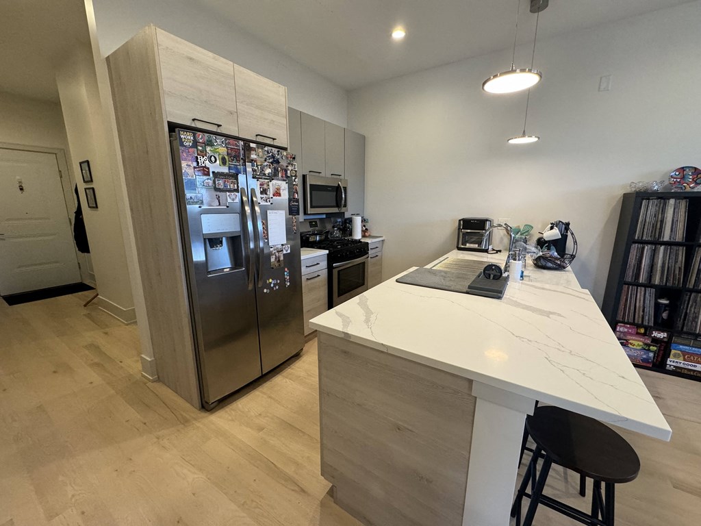 a kitchen with a large island and a stainless steel refrigerator