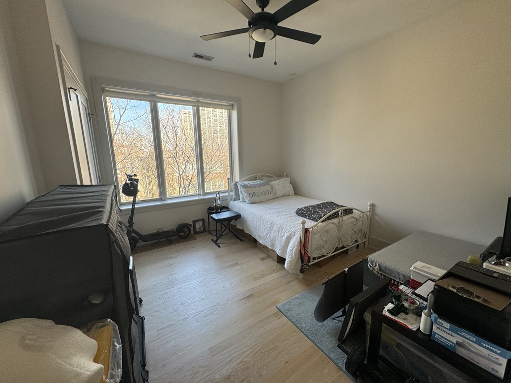 a bedroom with a bed and a ceiling fan