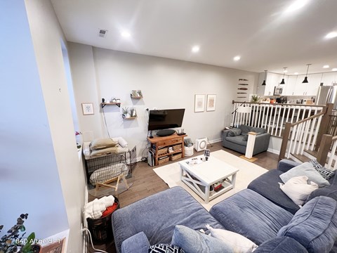 A living room with a grey sofa and a white coffee table.