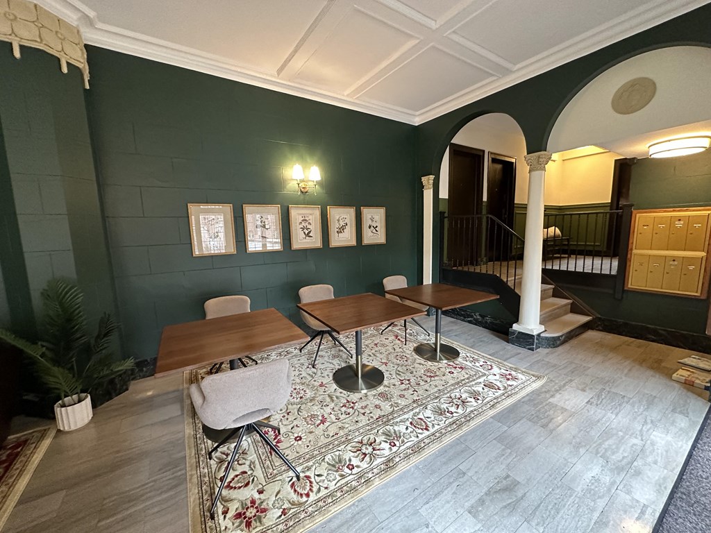 a dining room with green walls and a wooden table and chairs