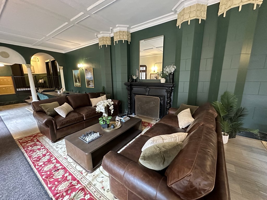 a living room with green walls and leather furniture