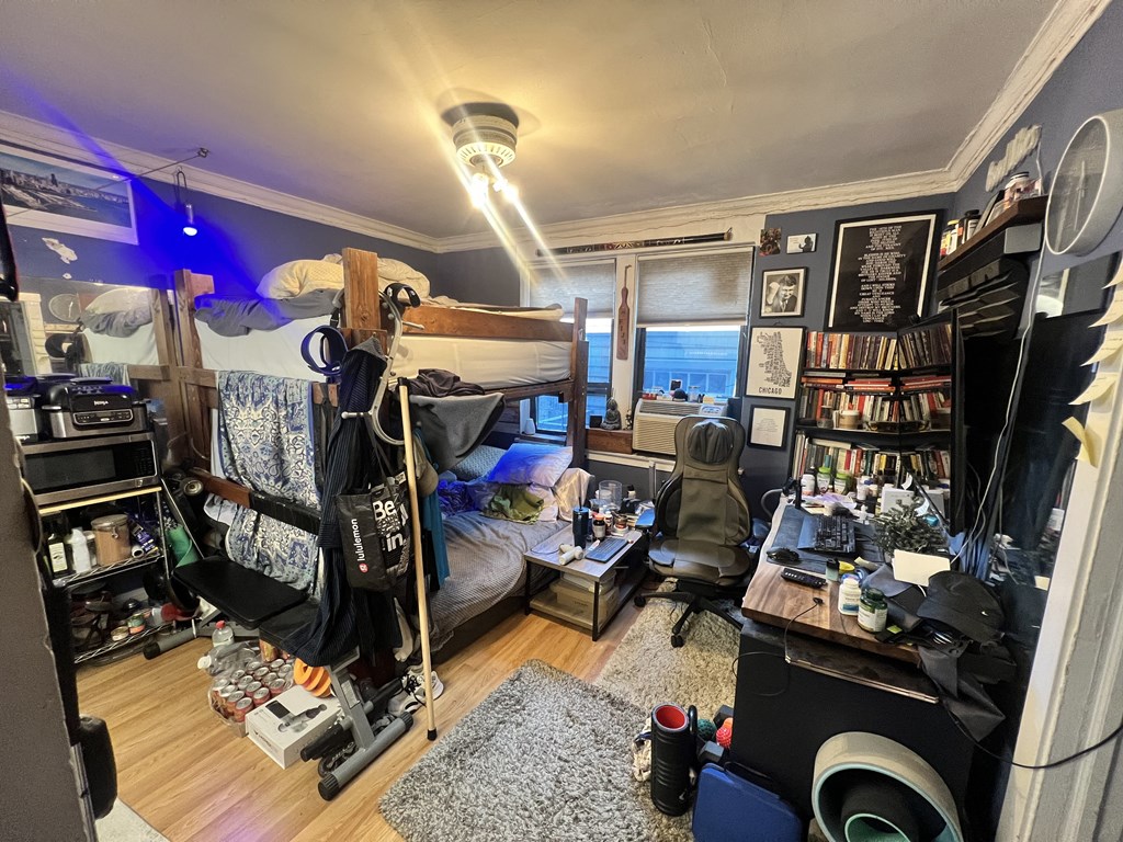 a bedroom with a bunk bed and a desk and a window