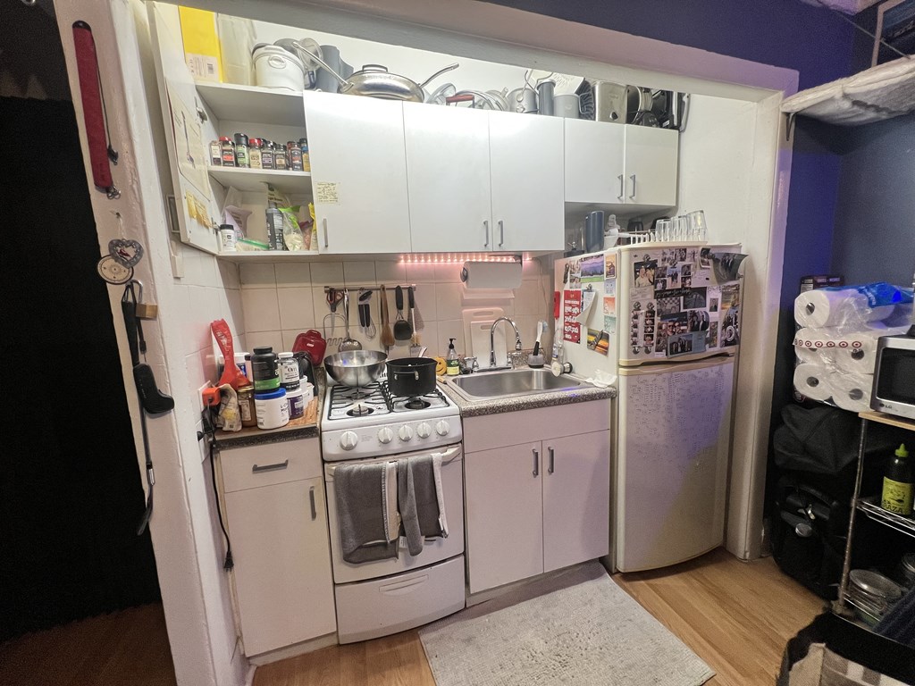 a small kitchen with white appliances and white cabinets