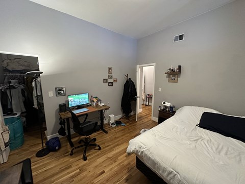 A room with a bed, desk, and chair.