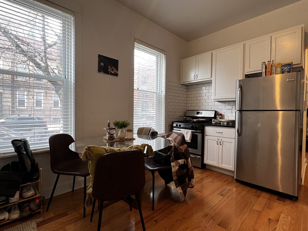 an open kitchen and dining room with a table and chairs and a refrigerator