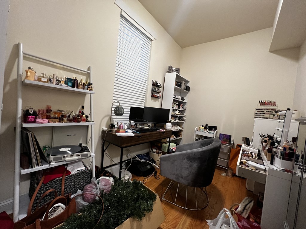 a cluttered room with a computer desk and a chair