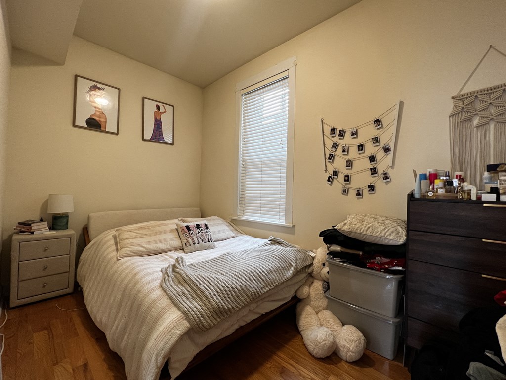 a bedroom with a bed and a dresser and a window
