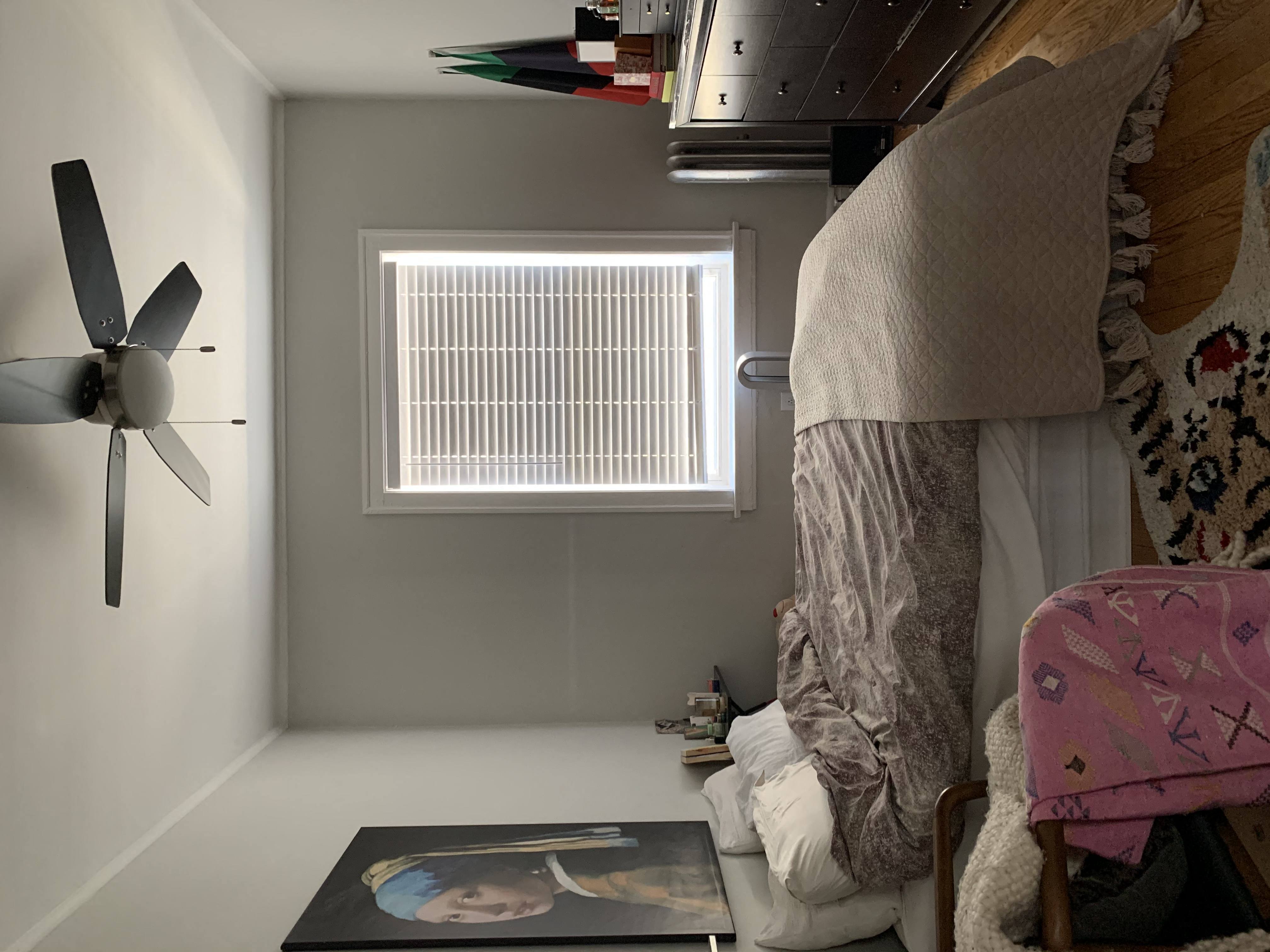 a room with a bed and a ceiling fan