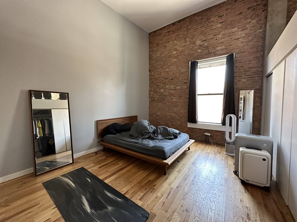 a bedroom with a bed and a mirror on the wall