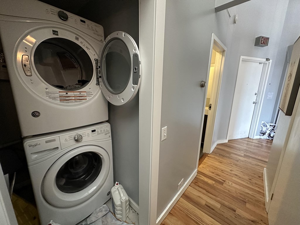 a washer and dryer in a laundry room with a door to the hallway