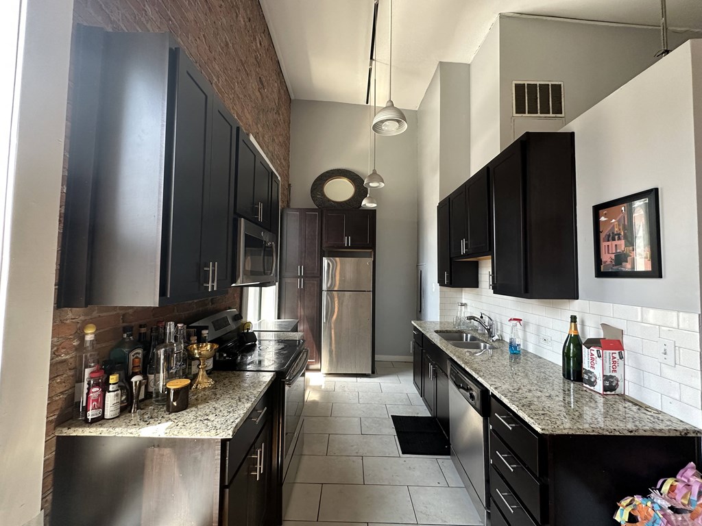 a kitchen with black cabinets and a granite counter top