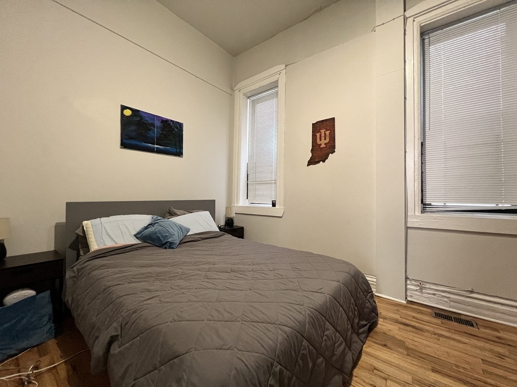 a bedroom with a bed and two windows