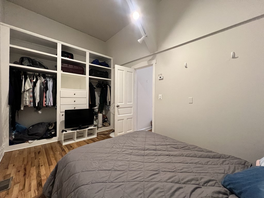 a bedroom with a large bed and a closet with a tv