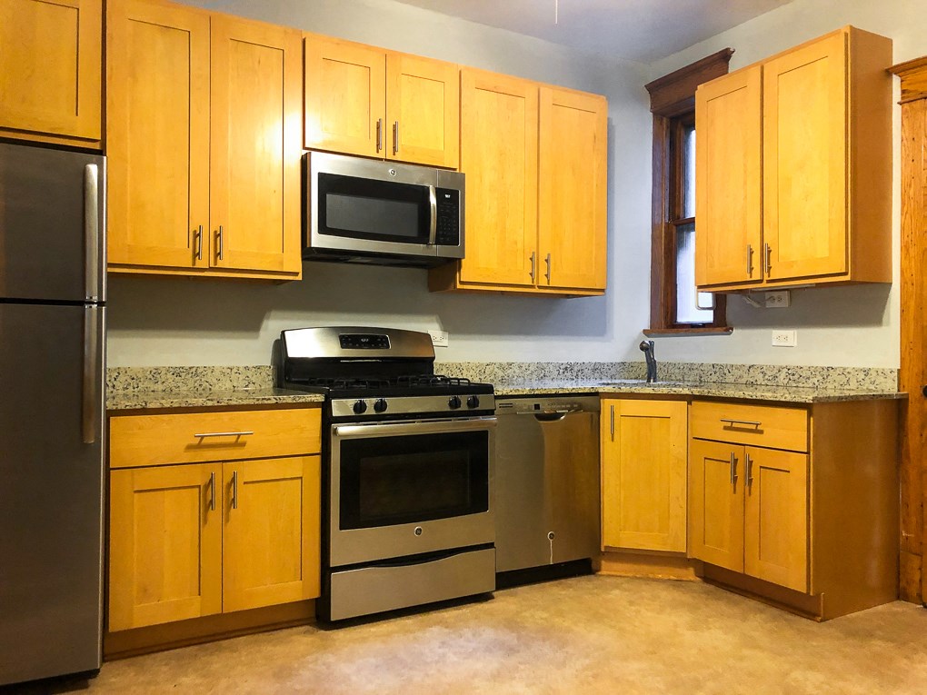 a kitchen with stainless steel appliances and wooden cabinets