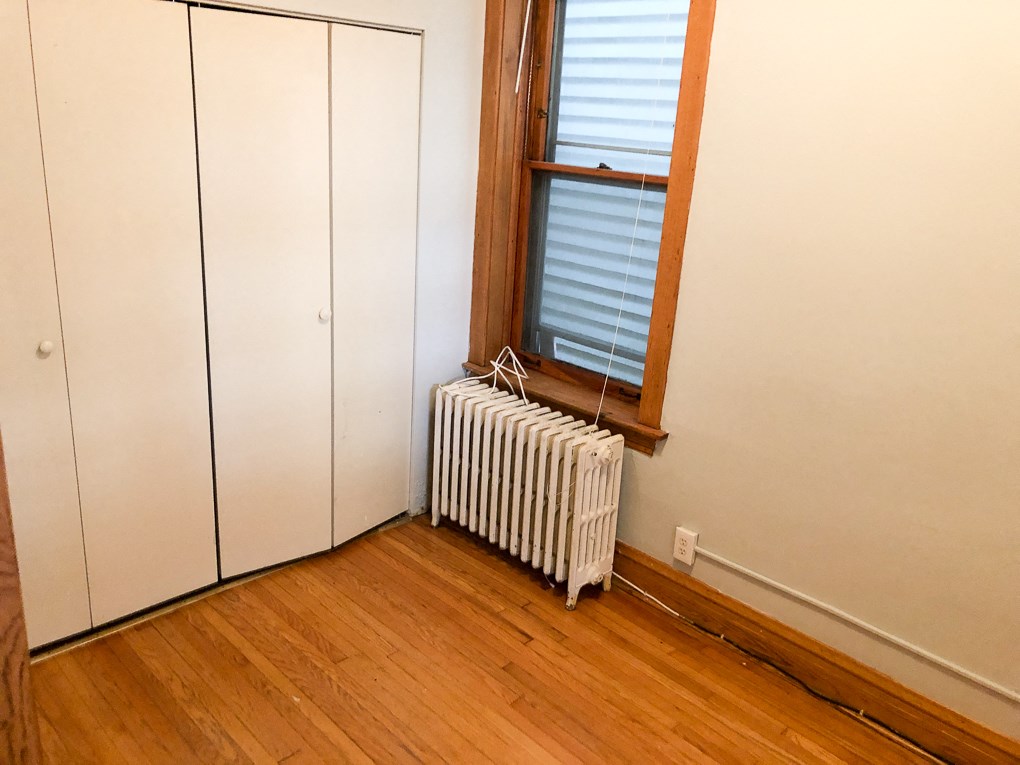 a radiator sitting under a window in a room with wooden floors