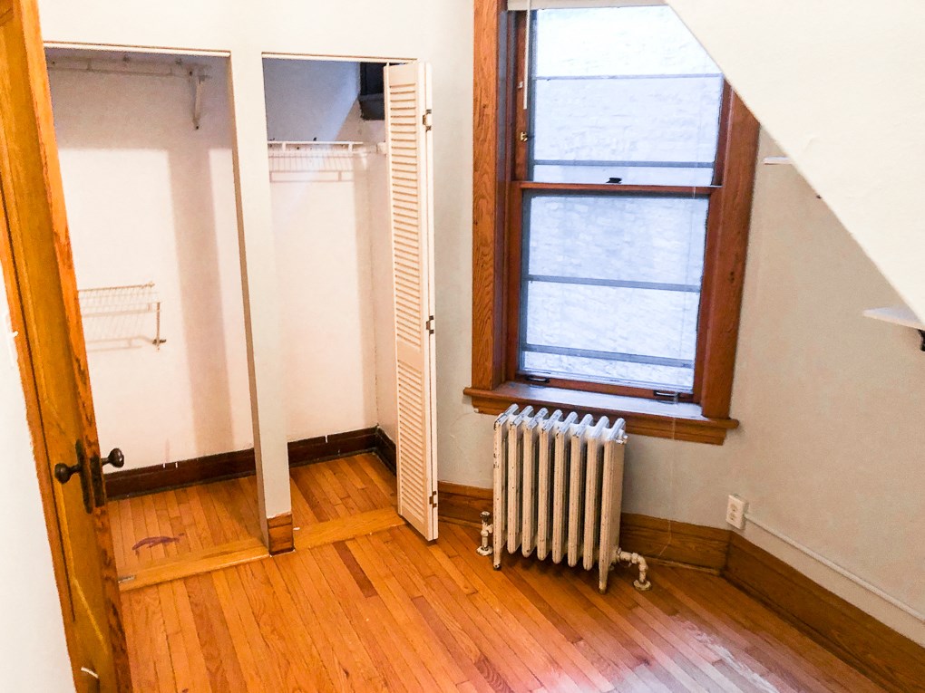 a room with a radiator and a window and a closet