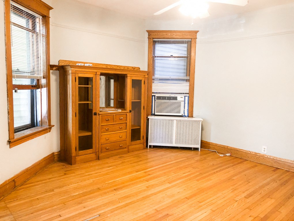 an empty living room with wood floors and a window