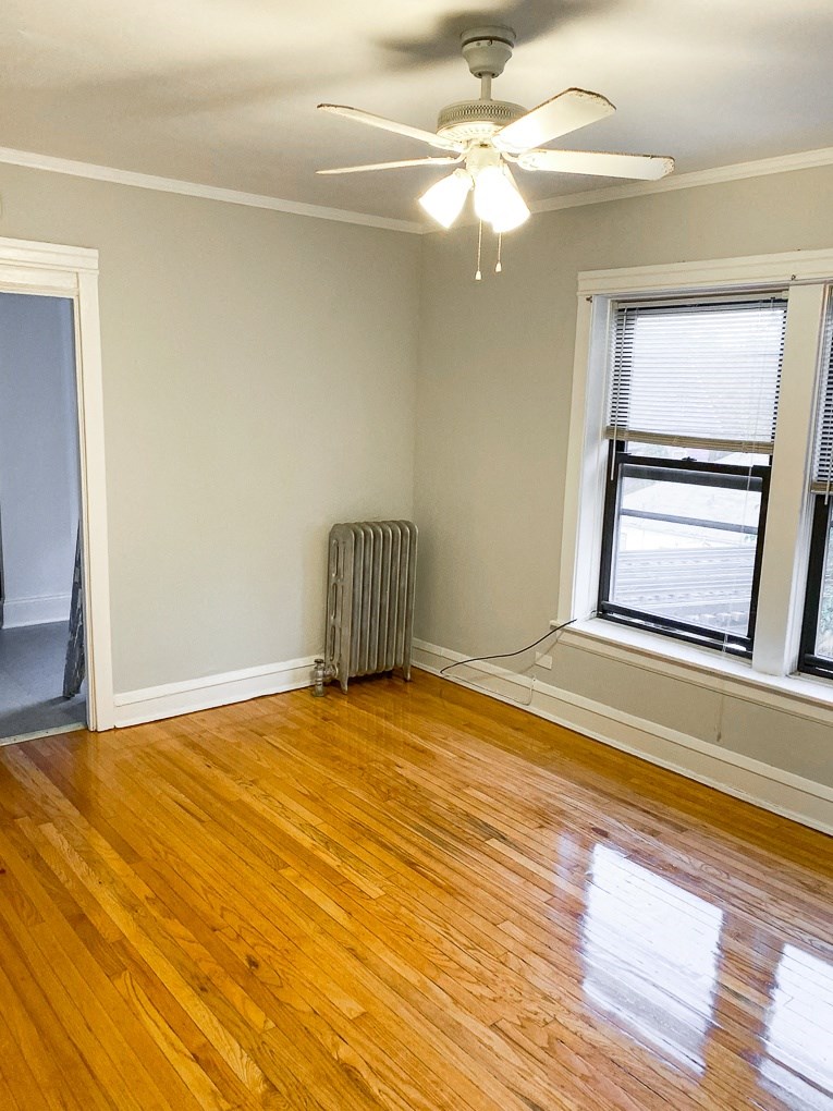 an empty room with wooden floors and a ceiling fan