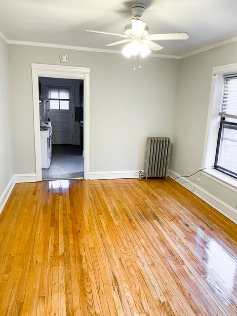 a living room with a hard wood floor and a ceiling fan