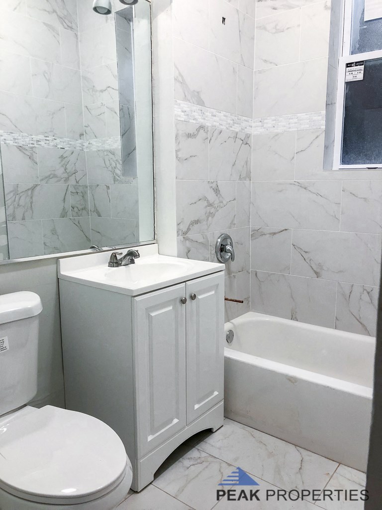 a bathroom with a toilet and a tub and a sink