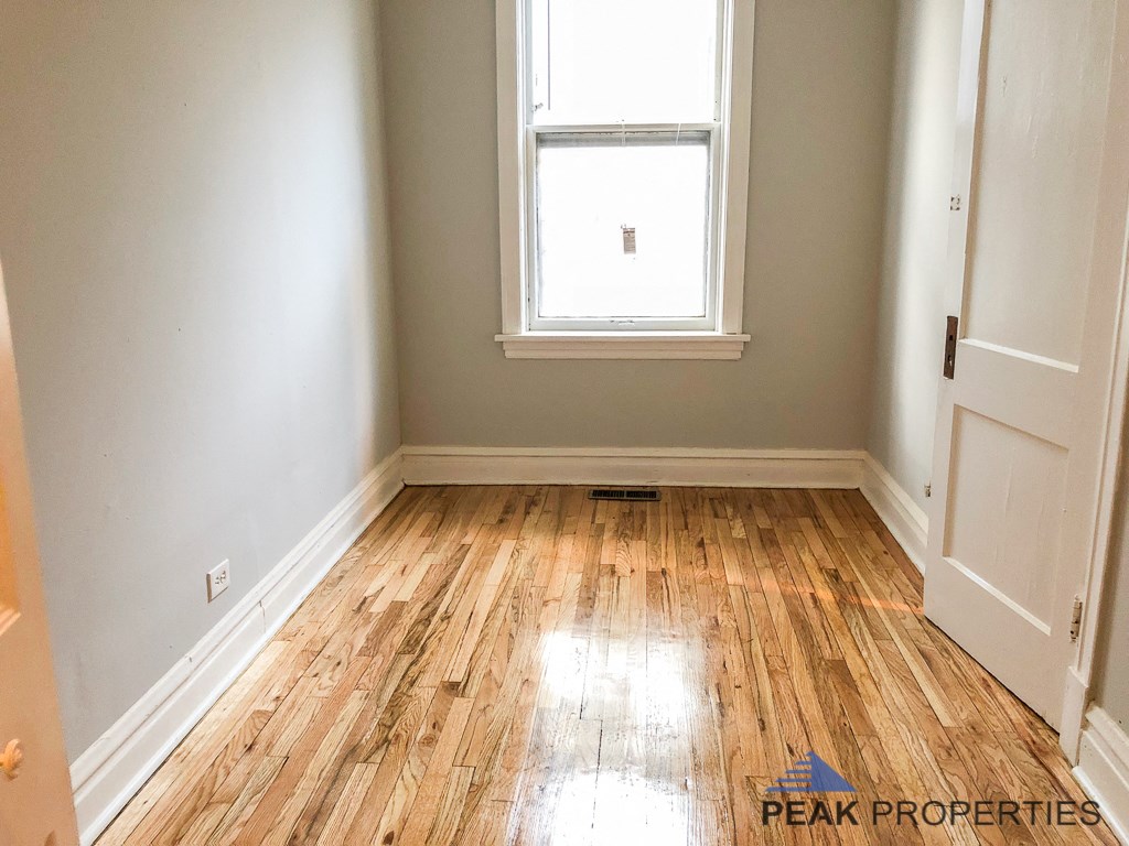 an empty room with wood floors and a window