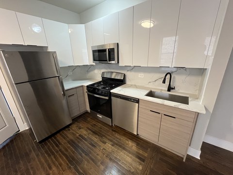 A kitchen with a stainless steel refrigerator, microwave, oven, and sink.