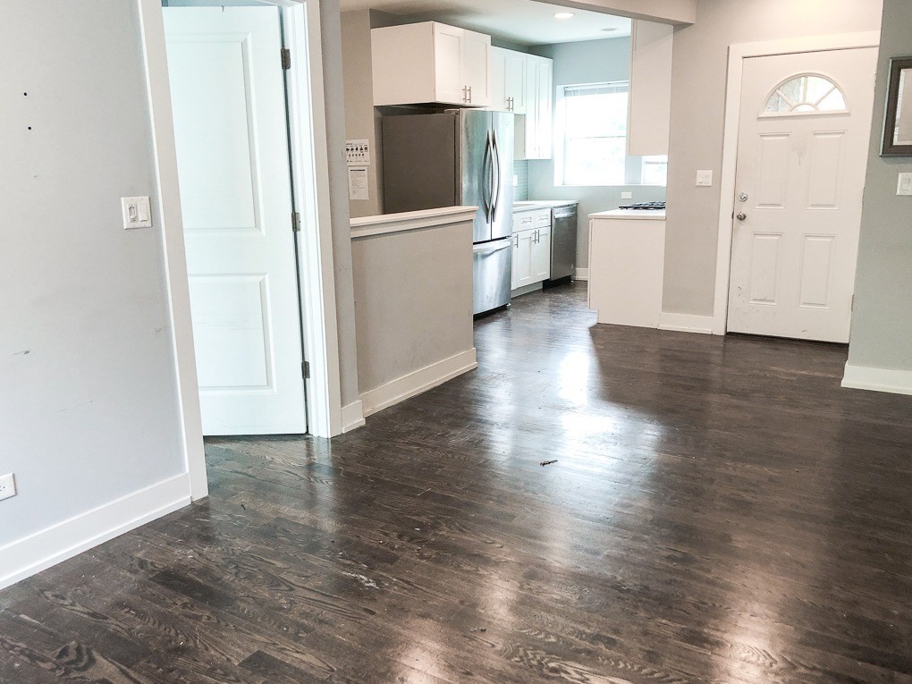 A kitchen with a white door and a white fridge.