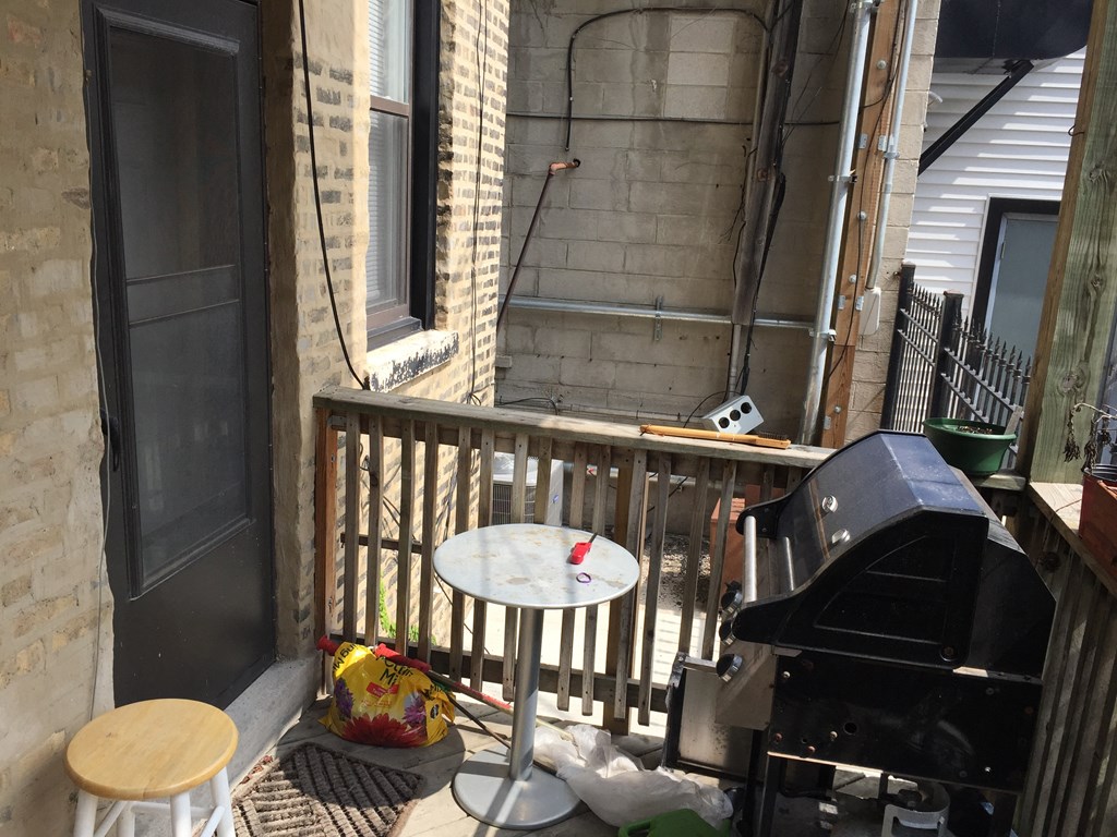 a patio with a grill and a table on a balcony