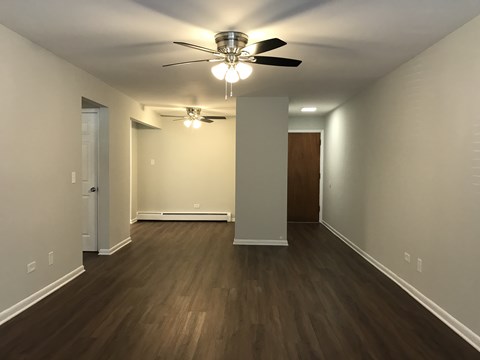 A room with a ceiling fan and light fixture.