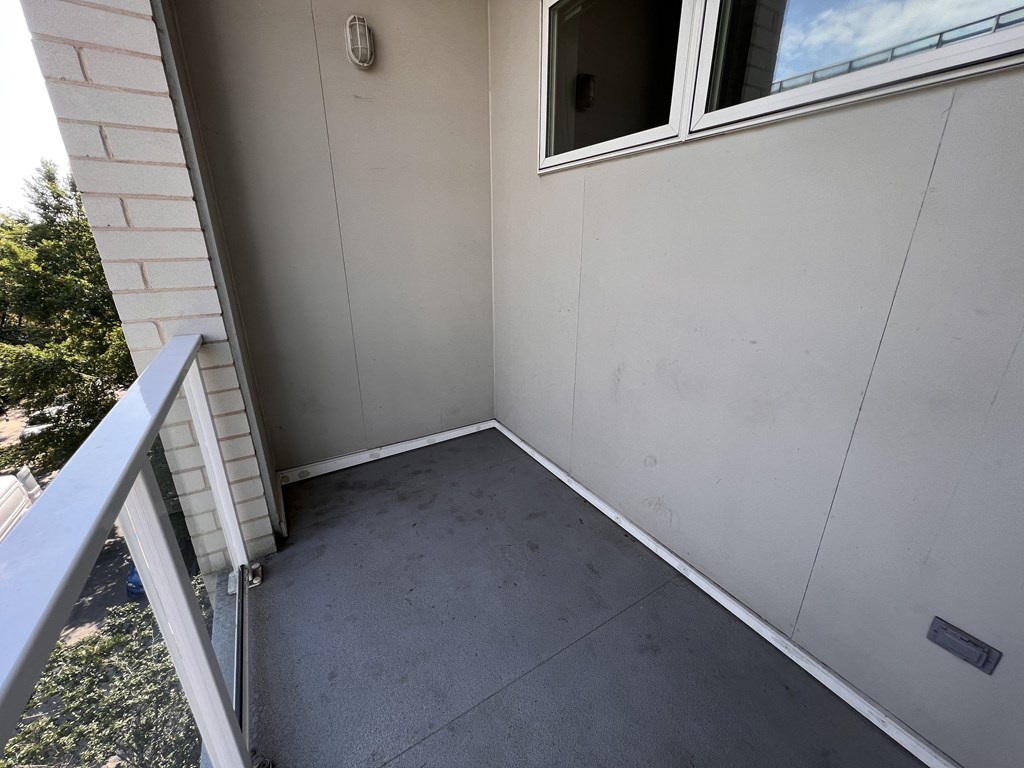 an empty porch at the end of a building with a window