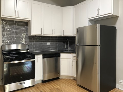 A kitchen with a stainless steel refrigerator, oven, and dishwasher.