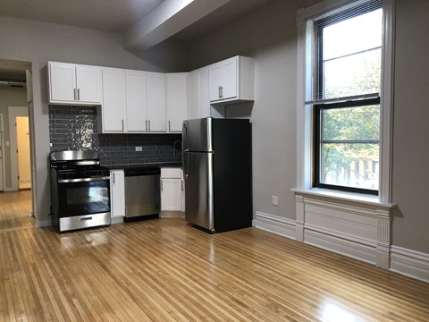 A kitchen with a black refrigerator and stainless steel appliances.